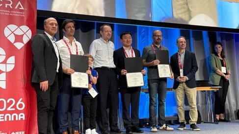 Dr Guangming Wang (middle) receiving recognition at ICRA 2026. Only five Outstanding Associate Editor Awards were presented worldwide.